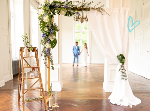 Photocall mariage photobooth : un rideau blanc est accroché à une arche