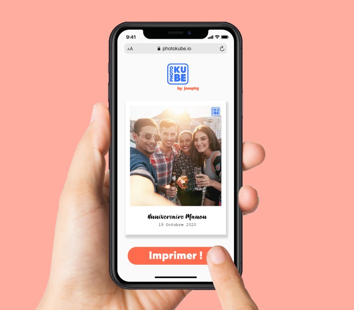 Une main tient un téléphone portable pour choisir la photo qu'elle veut imprimer à distance sur le PhotoKube