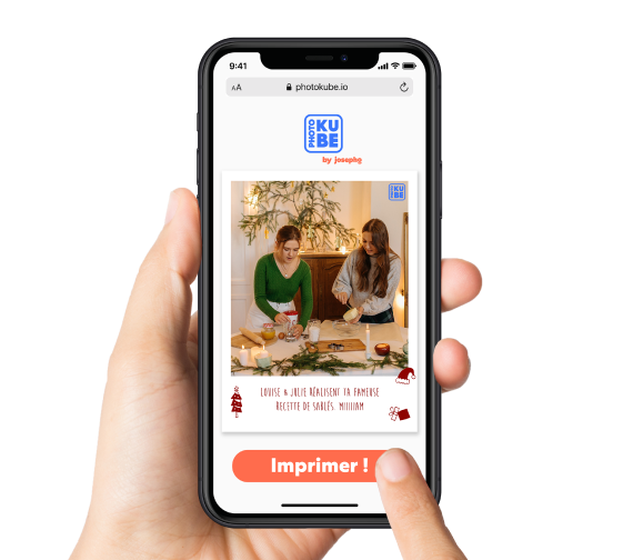 Une main tient un téléphone portable pour choisir la photo qu'elle veut imprimer à distance sur le PhotoKube